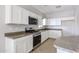 Contemporary kitchen featuring sleek white cabinets, stainless steel appliances, and ample counter space for food preparation at 14262 N 142Nd Ln, Surprise, AZ 85379