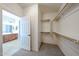 Open walk-in closet with a view of the bathroom, featuring convenient shelving and hanging rods at 14262 N 142Nd Ln, Surprise, AZ 85379
