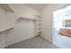 Bright walk-in closet with built-in shelves and rod, leading to a well-lit bathroom at 14262 N 142Nd Ln, Surprise, AZ 85379