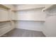 Spacious walk-in closet with custom shelving and rod system and carpet flooring at 14262 N 142Nd Ln, Surprise, AZ 85379