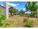 Spacious, grassy backyard featuring mature trees and a fenced garden area at 1451 E Brown Rd, Mesa, AZ 85203