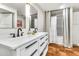 Stylish bathroom showcasing a double vanity, modern fixtures, and a shower behind neutral curtain at 1451 E Brown Rd, Mesa, AZ 85203