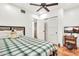 Bedroom boasts tile flooring, ceiling fan, and closet access, and has neutral paint colors at 1451 E Brown Rd, Mesa, AZ 85203