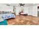 Large bedroom features two beds, tile floors, a ceiling fan, and neutral paint colors at 1451 E Brown Rd, Mesa, AZ 85203