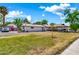 Expansive front yard featuring a single story home with a charming carport and vibrant turquoise doors at 1451 E Brown Rd, Mesa, AZ 85203