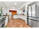 Modern kitchen featuring white cabinets, butcher block countertops, stainless steel fridge, and tiled floors at 1451 E Brown Rd, Mesa, AZ 85203
