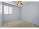 Bedroom offers neutral carpet, a ceiling fan, and a window with blinds for natural light at 14793 W Surrey Dr, Surprise, AZ 85379