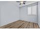 Bedroom boasts wood floors, a modern fan, and bright natural light from the window at 14793 W Surrey Dr, Surprise, AZ 85379