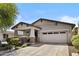 A beautifully designed house with a covered porch, a garage, and neat landscaping at 14793 W Surrey Dr, Surprise, AZ 85379