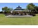 Community gazebo with blue metal roof and stone supports surrounded by green grass and shade trees at 14793 W Surrey Dr, Surprise, AZ 85379