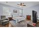 Main bedroom with hardwood floors, ceiling fan, a sitting area, and natural light from the windows at 14793 W Surrey Dr, Surprise, AZ 85379