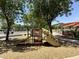 Community playground surrounded by mature trees and a shade canopy at 14793 W Surrey Dr, Surprise, AZ 85379