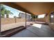 A cozy covered back patio with a view of the spacious yard and a block fence for privacy at 15025 W Bottle Tree Ave, Surprise, AZ 85374