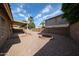 Gravel backyard with a covered patio, brick fire pit, block fencing, and desert landscaping offers relaxation at 15025 W Bottle Tree Ave, Surprise, AZ 85374