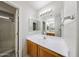 Bright bathroom featuring a vanity with a large mirror and walk-in shower at 15025 W Bottle Tree Ave, Surprise, AZ 85374