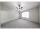Bright bedroom featuring neutral gray carpet, ceiling fan, and a window at 15025 W Bottle Tree Ave, Surprise, AZ 85374