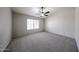 Bright bedroom featuring neutral gray carpet, ceiling fan, and a window at 15025 W Bottle Tree Ave, Surprise, AZ 85374