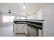 Kitchen island with stainless steel sink and dishwasher, with white cabinets and dark countertops at 15025 W Bottle Tree Ave, Surprise, AZ 85374