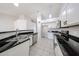 Bright open kitchen featuring stainless steel appliances, tile flooring and black countertops at 15025 W Bottle Tree Ave, Surprise, AZ 85374