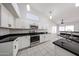 Bright kitchen features white cabinets, black countertops, tile floors, and stainless steel appliances at 15025 W Bottle Tree Ave, Surprise, AZ 85374
