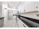 Kitchen featuring white cabinets, black countertops, stainless steel appliances, and tile flooring at 15025 W Bottle Tree Ave, Surprise, AZ 85374