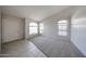 Bright living room featuring neutral carpet, white walls, tile entry, and arched windows at 15025 W Bottle Tree Ave, Surprise, AZ 85374