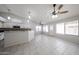 Bright living room featuring neutral walls, tile flooring, ceiling fans, and natural lighting from large windows at 15025 W Bottle Tree Ave, Surprise, AZ 85374