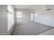 Bright living room featuring neutral carpet, white walls, tile entry, and arched windows at 15025 W Bottle Tree Ave, Surprise, AZ 85374