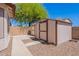 Backyard features multiple sheds, concrete walkways, and desert landscaping at 1563 E Racine Dr, Casa Grande, AZ 85122