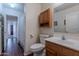 Cozy bathroom with wooden cabinets, vanity, toilet, mirror, and a doorway view to the shower at 1563 E Racine Dr, Casa Grande, AZ 85122
