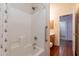 Bright bathroom featuring a shower with floral curtains and safety bar, alongside the sink and toilet area at 1563 E Racine Dr, Casa Grande, AZ 85122