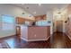 Open kitchen with wood cabinets, bar seating, and hardwood floors, perfect for entertaining guests at 1563 E Racine Dr, Casa Grande, AZ 85122