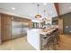 Kitchen island with bar seating, stainless steel fridge, and hardwood flooring at 16008 N 60Th St, Scottsdale, AZ 85254