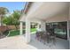 Enjoy the covered patio with a table that overlooks the yard, pool, and orange tree at 16008 N 60Th St, Scottsdale, AZ 85254