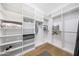 Custom walk-in closet with white built-in shelves and wooden floors at 16008 N 60Th St, Scottsdale, AZ 85254