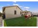 Backyard showcasing the lawn, seating area, hot tub, and neutral colored exterior at 1601 S 215Th Dr, Buckeye, AZ 85326
