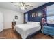 Cozy bedroom showcasing wood floors, ceiling fan, and stylish decor at 1601 S 215Th Dr, Buckeye, AZ 85326