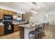 Well-lit kitchen featuring a breakfast bar, ample counter space, and black appliances at 1601 S 215Th Dr, Buckeye, AZ 85326