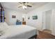 Bright primary bedroom featuring wood floors, ceiling fan, and ensuite bathroom at 1601 S 215Th Dr, Buckeye, AZ 85326