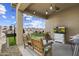 Inviting covered patio with outdoor seating, TV, and open view to the backyard at 1601 S 215Th Dr, Buckeye, AZ 85326