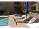 Poolside view with lounge chairs, blue umbrellas, and a clear blue pool, with palm trees and a jacuzzi at 16631 E El Lago Blvd # 212, Fountain Hills, AZ 85268
