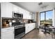 Bright kitchen with stainless steel appliances, white cabinets, and a cozy breakfast nook with a view at 17 W Vernon Ave # 412, Phoenix, AZ 85003