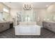 Elegant bathroom showcasing a soaking tub, dual vanities, and a luxurious walk-in shower with glass door at 1704 E Melrose St, Mesa, AZ 85203
