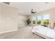 Bright main bedroom boasts large windows, neutral tones, and plush carpet, with a leafy outdoor view at 1704 E Melrose St, Mesa, AZ 85203