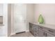 A modern mud room featuring gray cabinets and light tile floors adds style and function to the entry of this home at 1704 E Melrose St, Mesa, AZ 85203