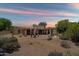 Backyard patio with desert landscaping under a colorful sky at sunset at 1725 E Staghorn Ln, Carefree, AZ 85377