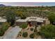 Desert home featuring a driveway, natural landscaping, and a desert backdrop at 1725 E Staghorn Ln, Carefree, AZ 85377