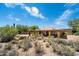 View of a single-story home with desert landscaping, including cacti and native plants, under a bright blue sky at 1725 E Staghorn Ln, Carefree, AZ 85377