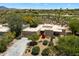 Expansive desert property with a long driveway, lush plants, and nearby golf course at 1725 E Staghorn Ln, Carefree, AZ 85377