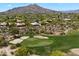 Golf course view with a green, sand traps, desert plants and homes scattered throughout the landscape at 1725 E Staghorn Ln, Carefree, AZ 85377